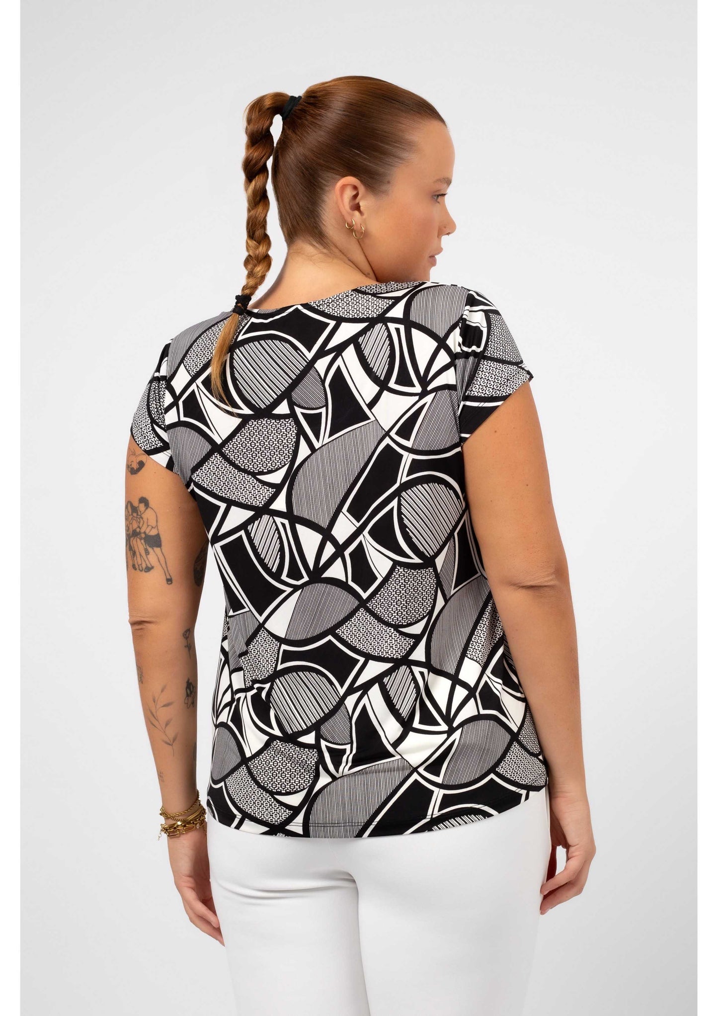 Blusa feminina malha plus size com estampa geométrica preta e branca vista de costas