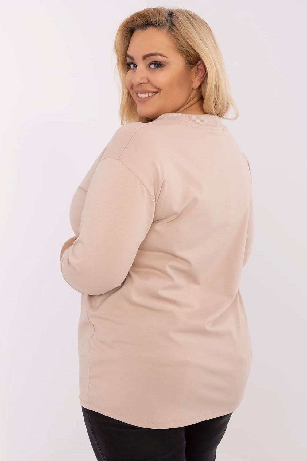 Mulher usando blusa manga longa plus size bege vista de costas sorrindo