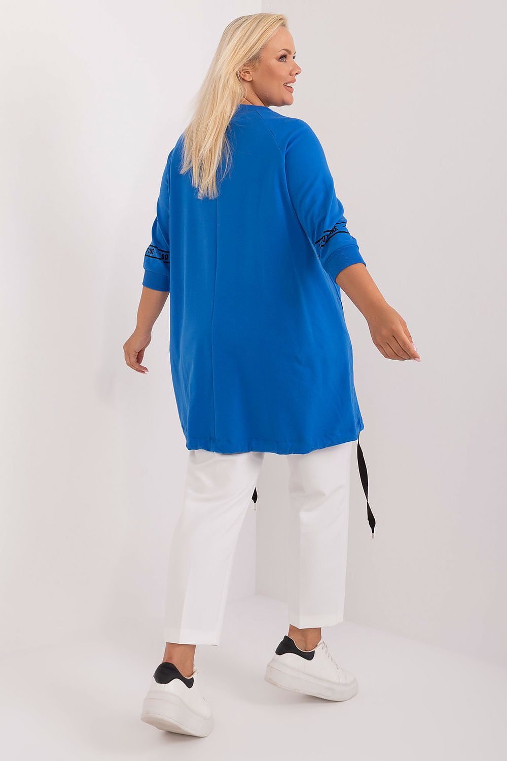 Blusa plus size feminina azul com calça branca e tênis branco vista de costas