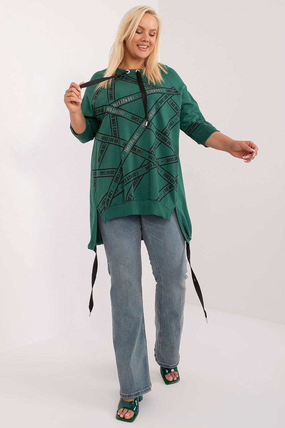 Blusa plus size feminina verde com capuz e detalhes pretos combinada com jeans azul