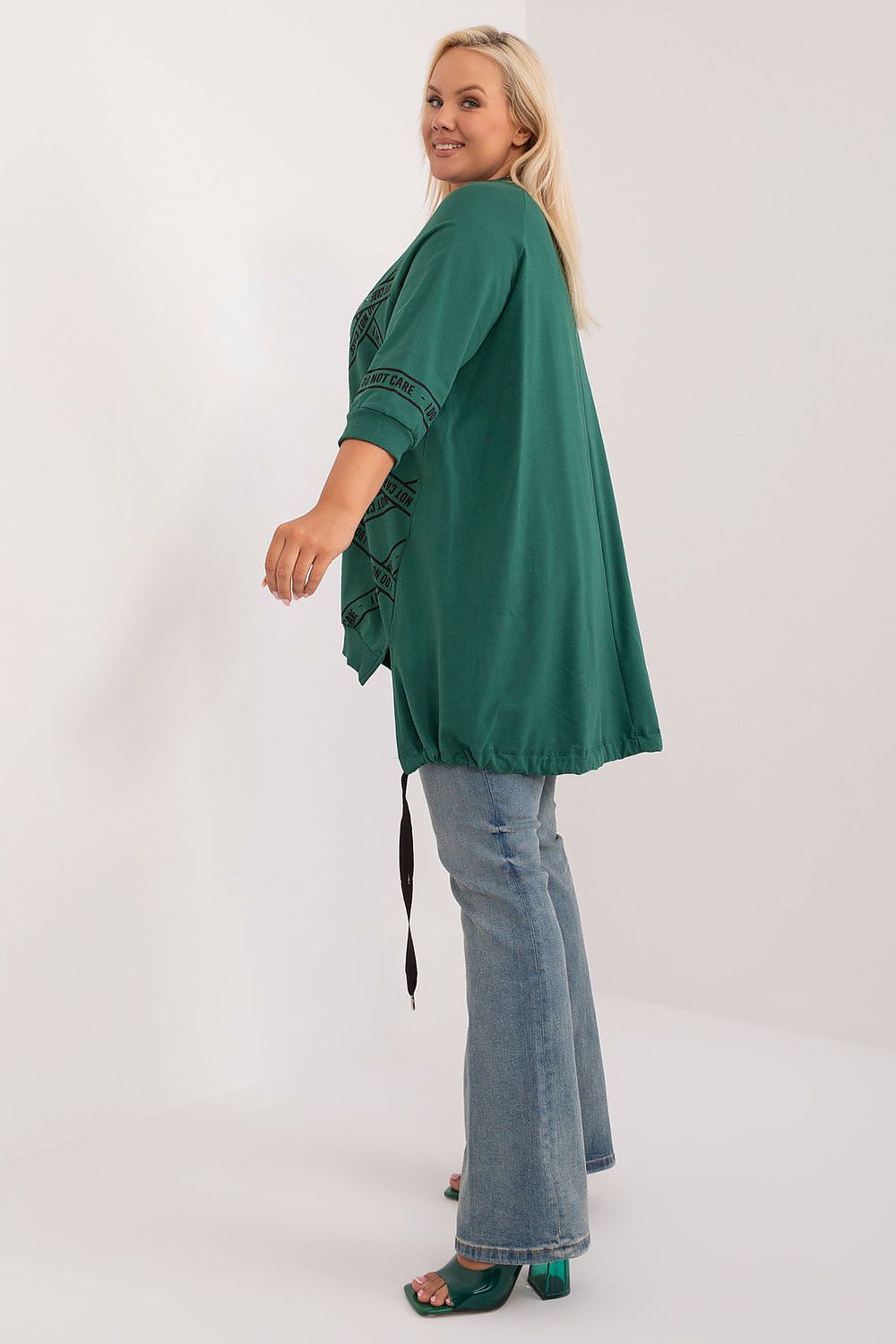 Blusa plus size feminina verde com manga 3/4 combinada com calça jeans e sandália verde