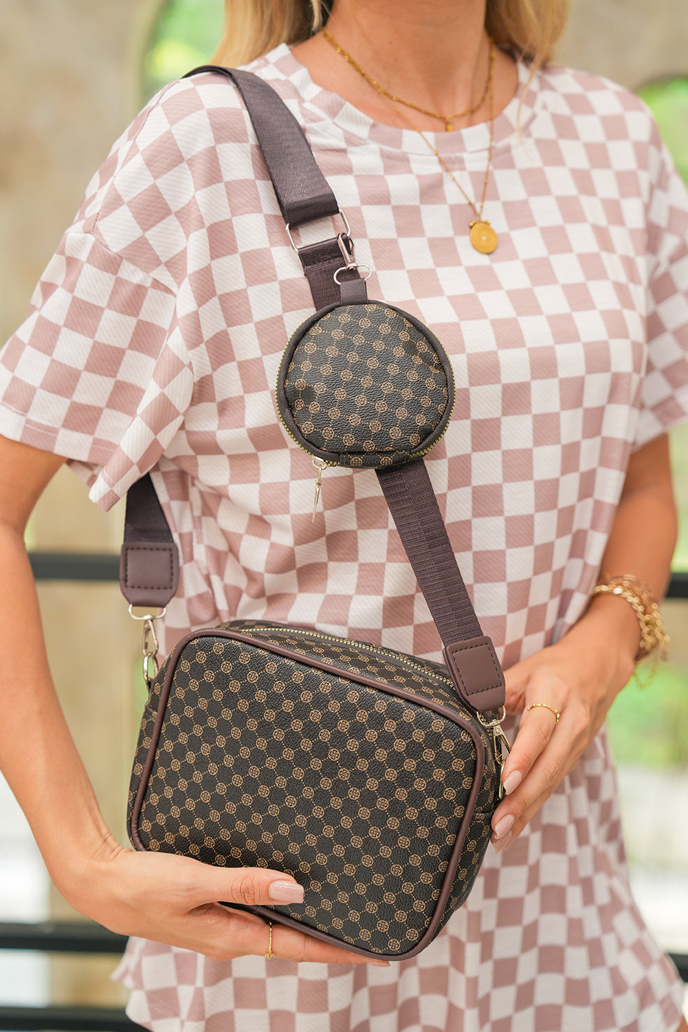 Bolsa tiracolo com estampa geometrica Shewin marrom com dois compartimentos, usada por mulher com vestido xadrez