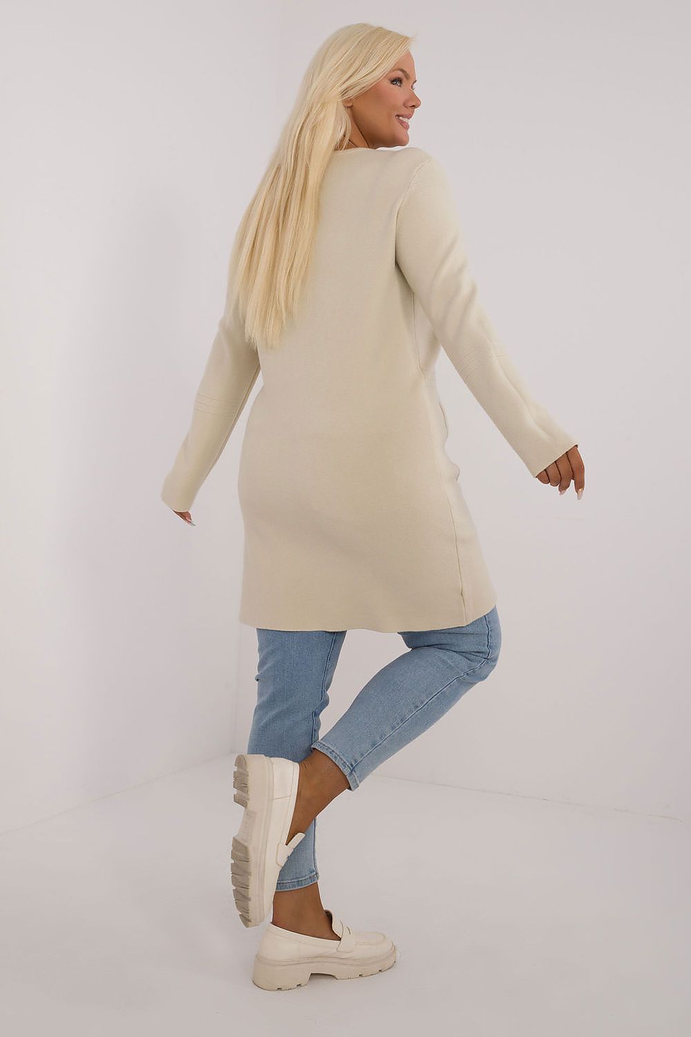 Casaco comprido plus size bege usado por mulher com calça jeans e tênis branco