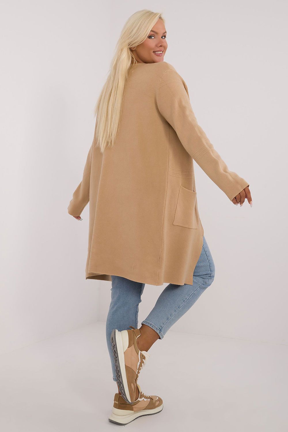 Casaco comprido plus size bege usado por mulher com jeans e tênis marrons
