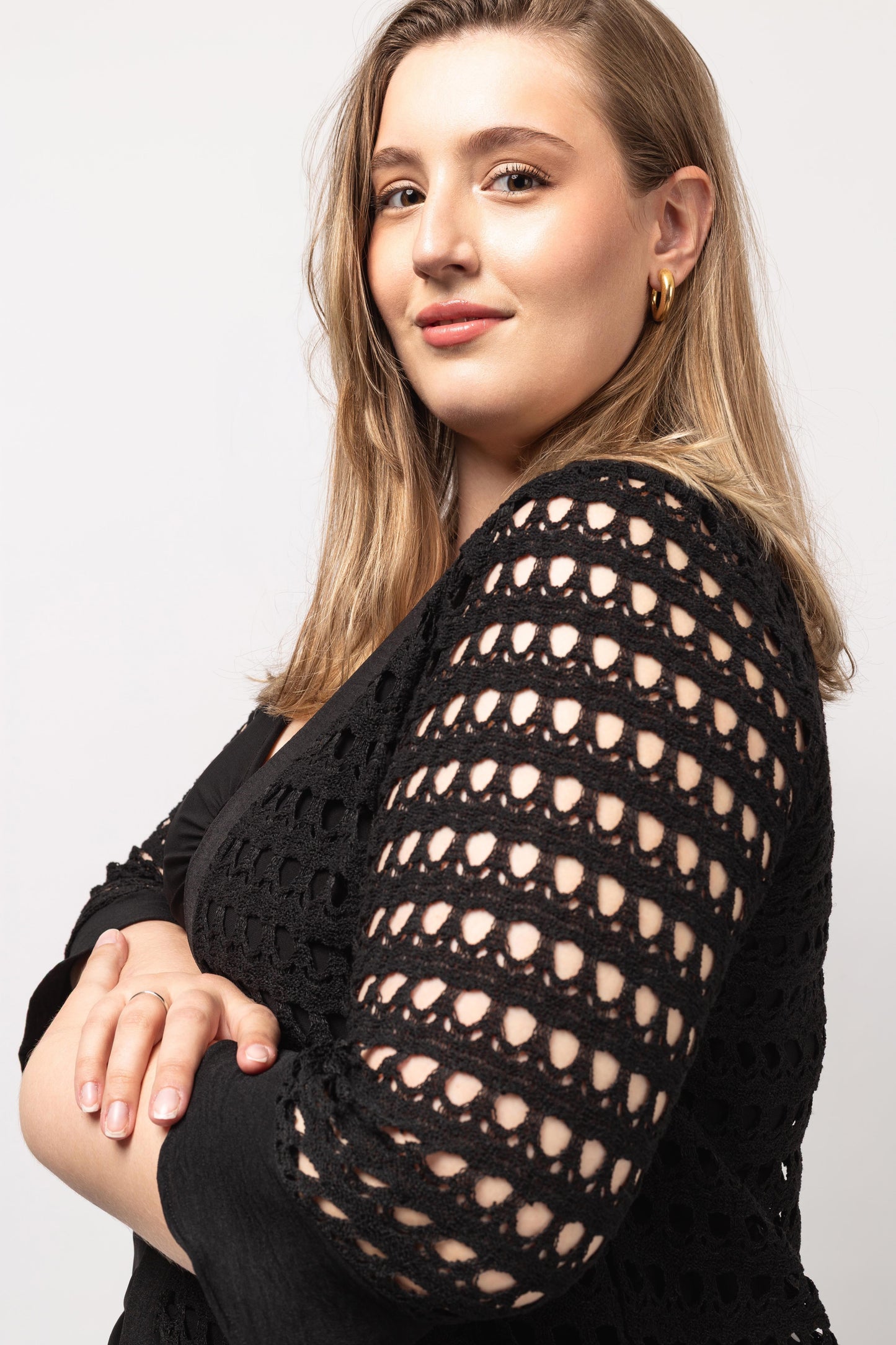 Mulher usando casaco de renda furada para mulheres preto com design elegante da Curvy