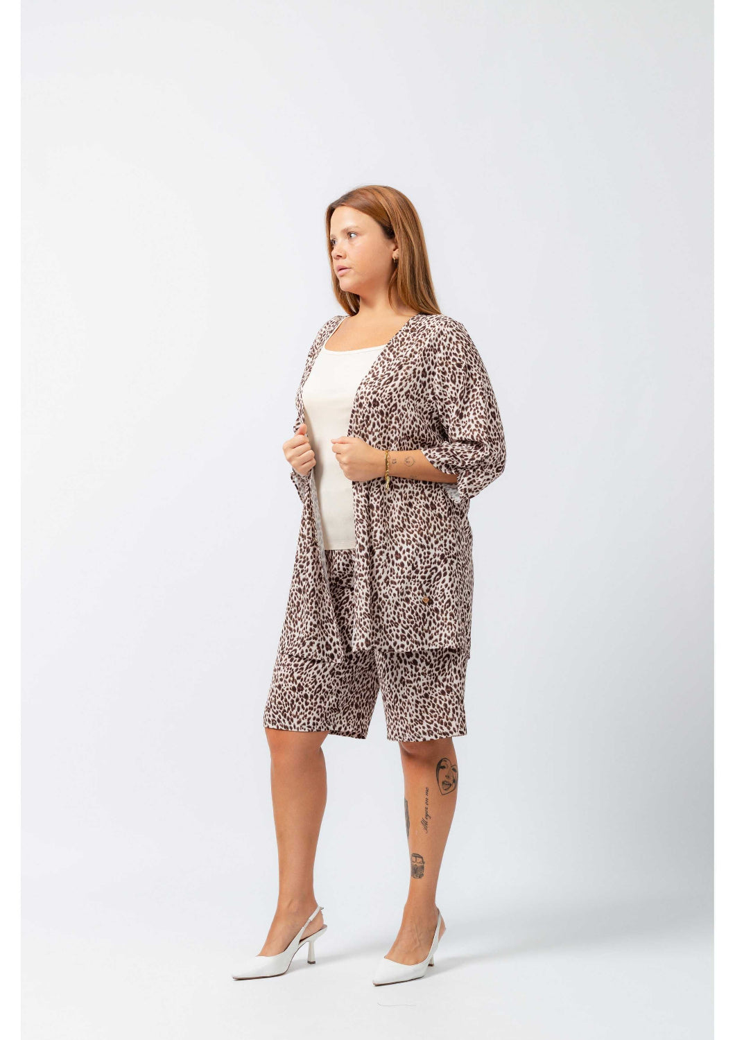 Mulher vestindo casaco estampado leopardo plus size com bermuda combinando e sapatos brancos