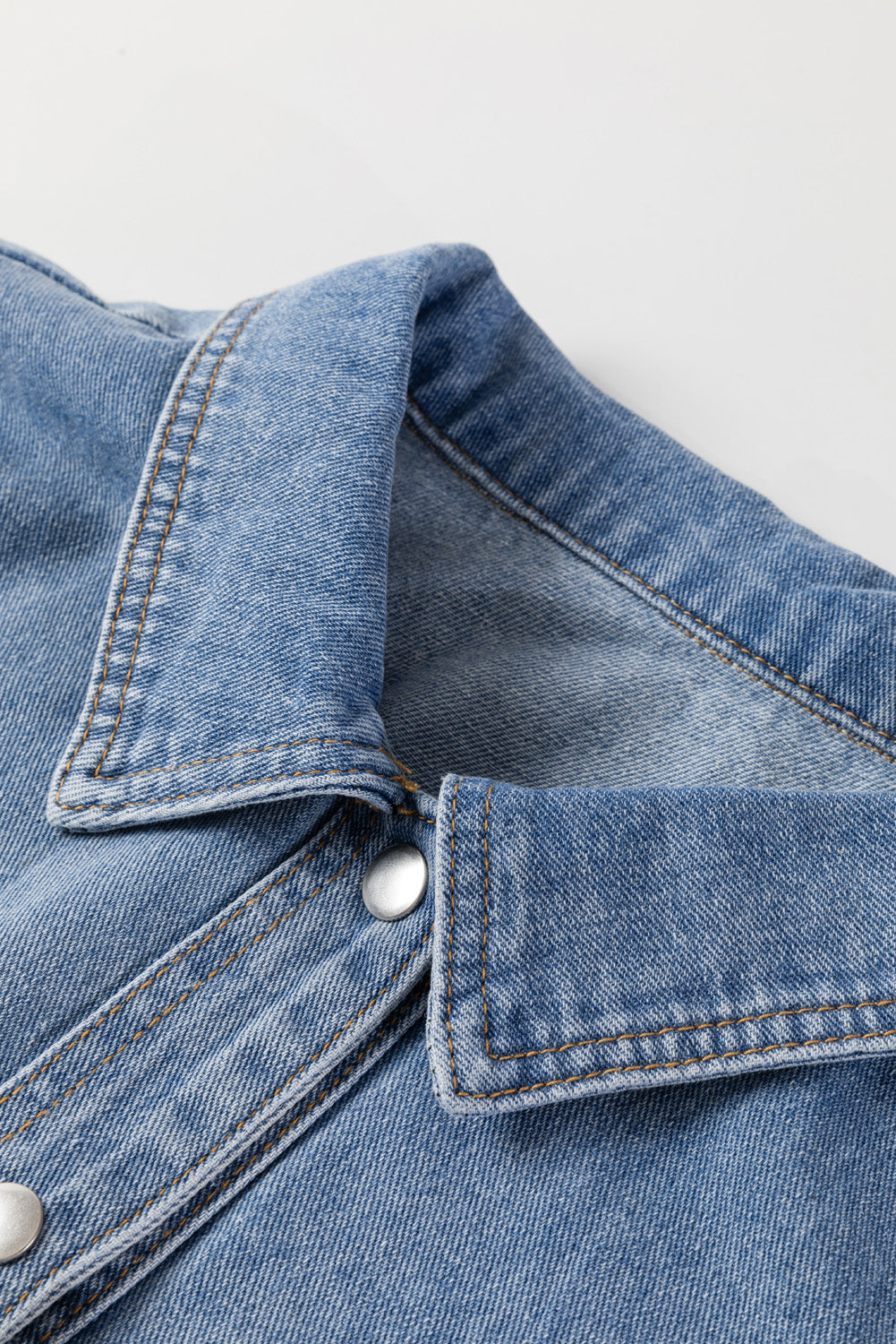 Detalhe do colarinho de casaco jeans plus size feminina azul com botões prateados da marca Shewin