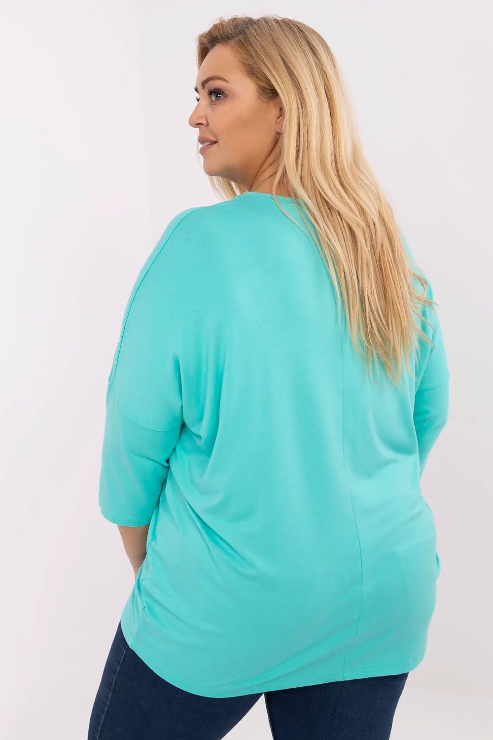 Mulher de costas usando blusa preta plus size com estampa, em tom azul claro, de manga três quartos