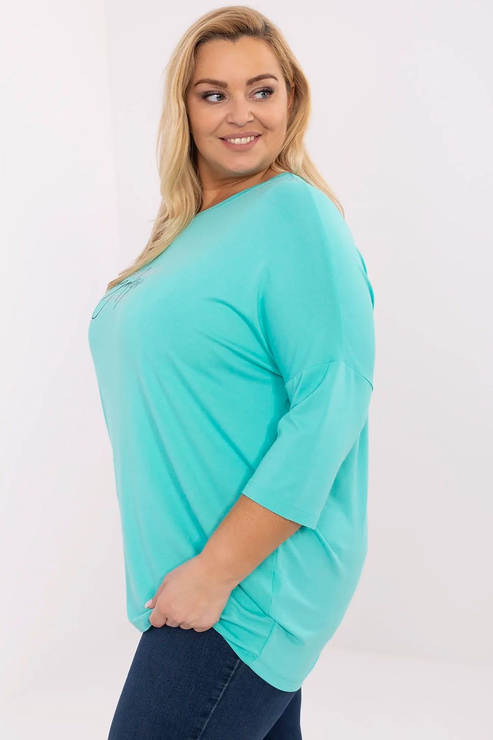 Mulher vestindo blusa preta plus size com estampa azul turquesa de manga três quartos