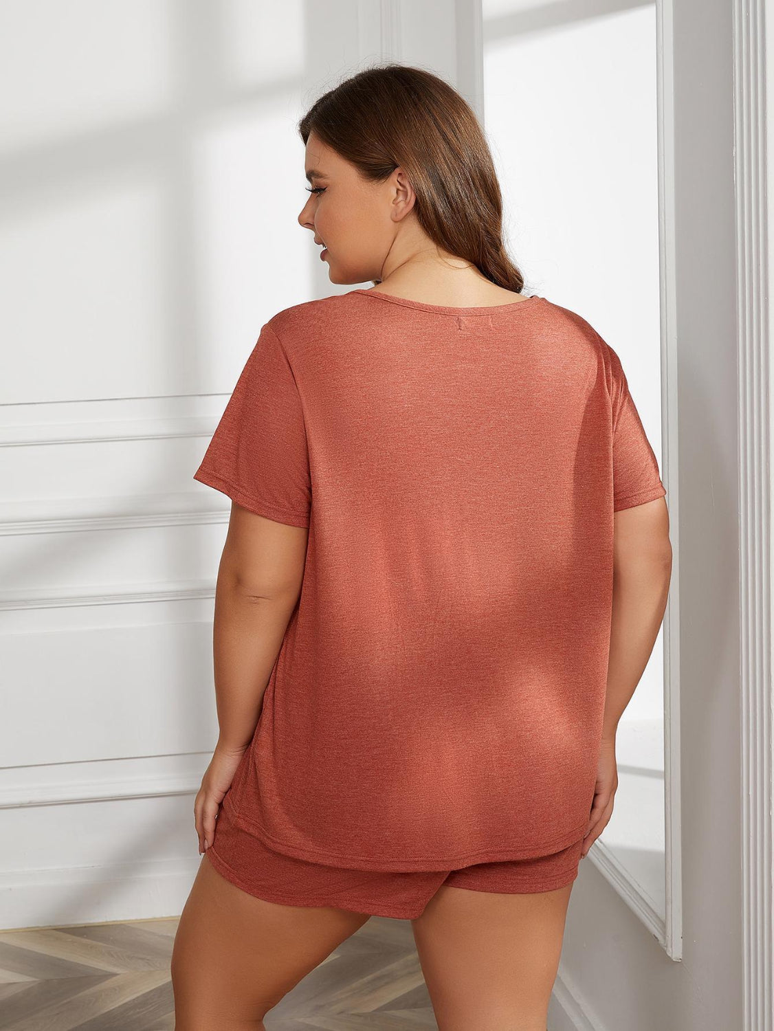 Mulher usando pijama manga curta tamanho grande em tom terracota da Trendsi vista de costas