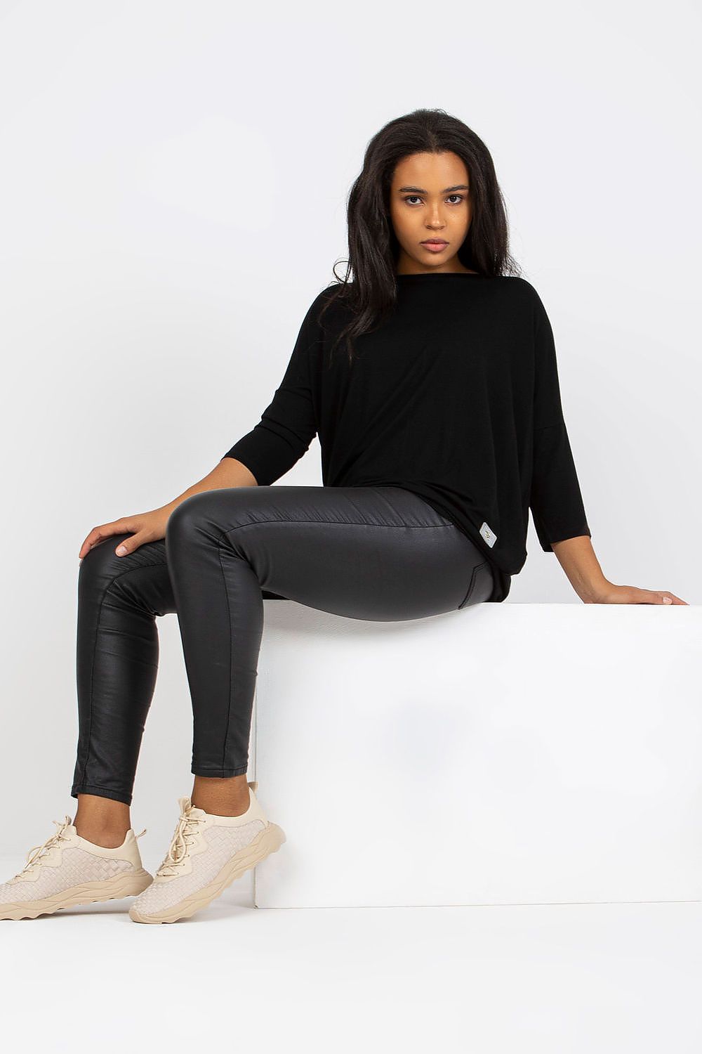 Mulher vestindo blusa tamanho grande moda curvy preta com calça legging preto brilhante