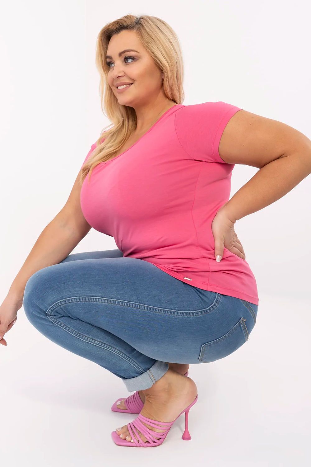 T-shirt preta plus size combinada com calça jeans azul e salto rosa