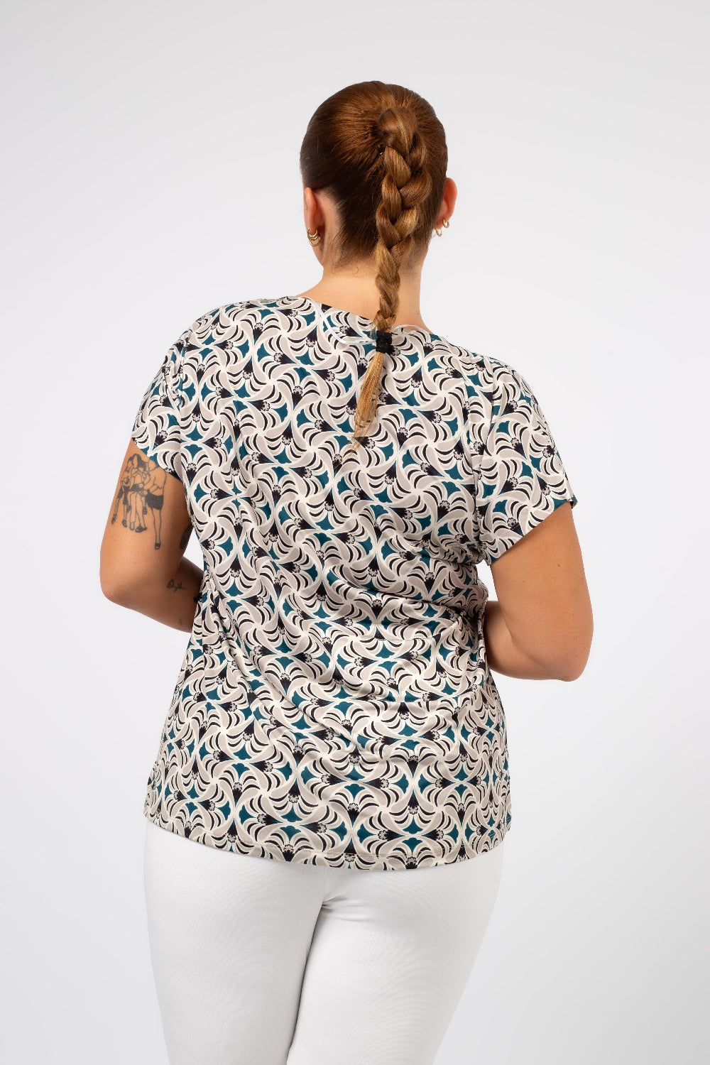 Mulher usando tunica estampada para mulheres curvy com padrão geométrico em tons neutros