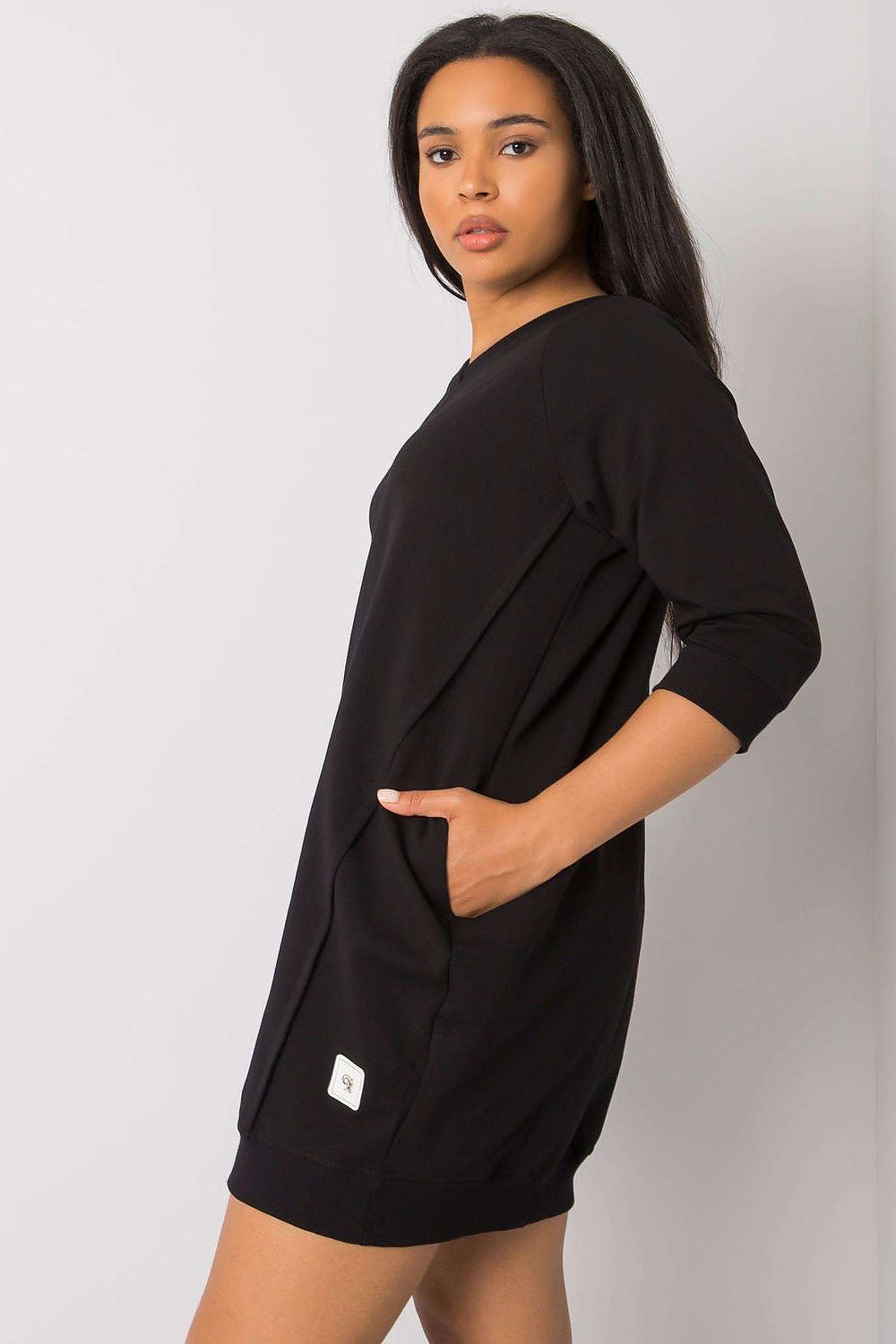 Mulher usando vestido casual plus size com bolsos preto com manga três quartos
