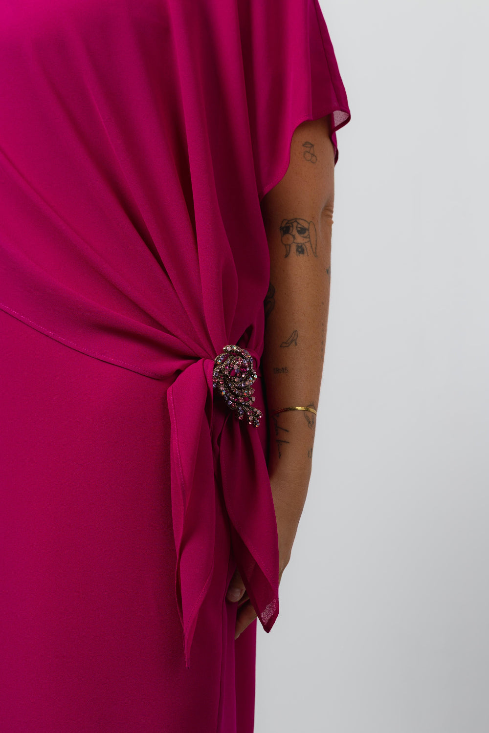Vestido elegante com capa sobreposta na cor rosa com detalhe de broche brilhante