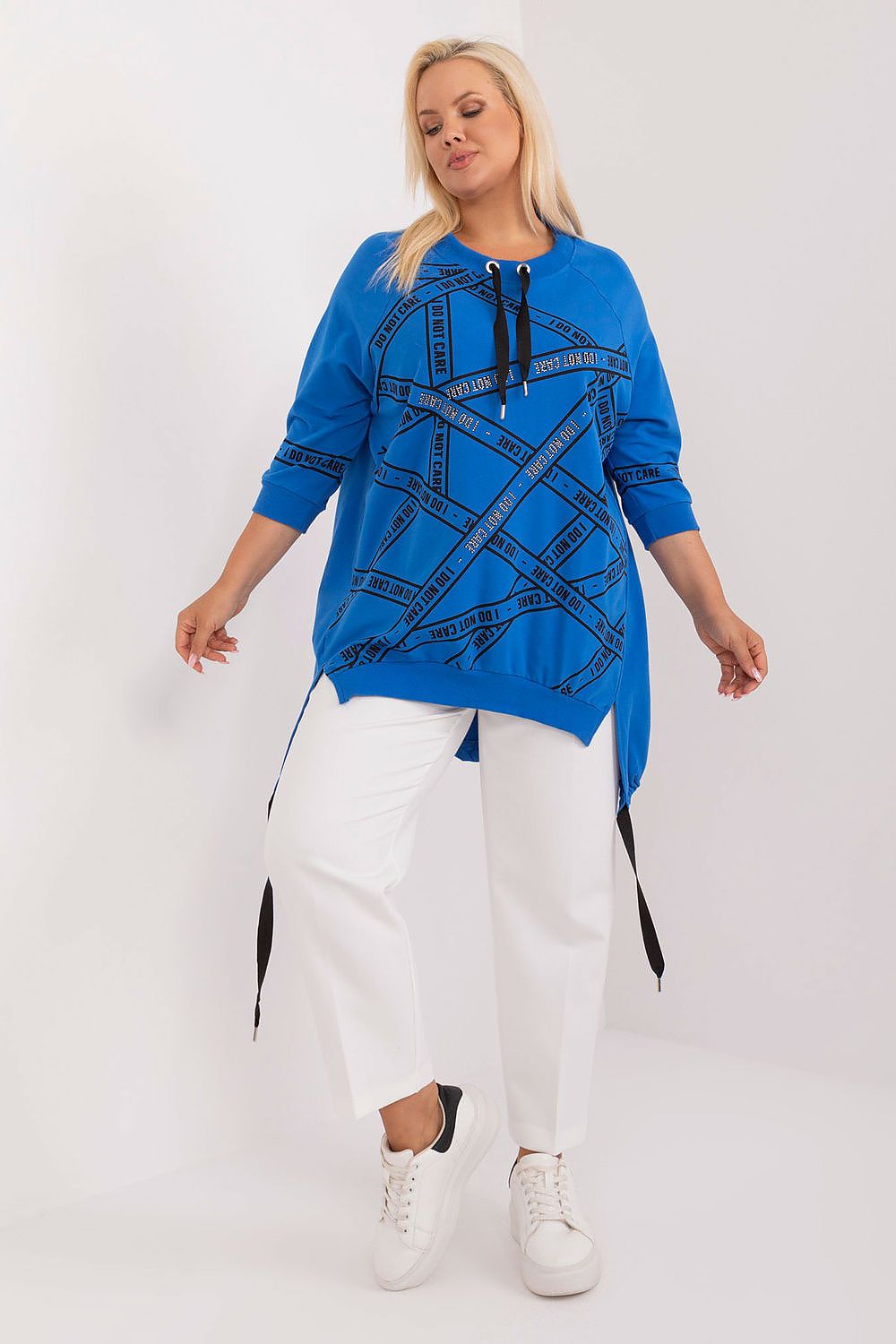 Blusa plus size feminina azul com estampa preta e detalhes com fitas, usada com calça branca