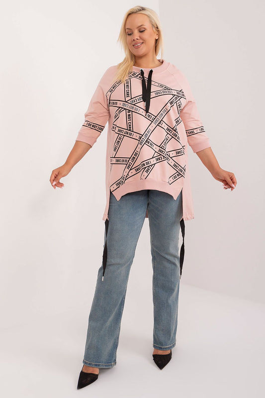 Blusa plus size feminina rosa com estampa preta e detalhes em cadarço, usada com calça jeans azul
