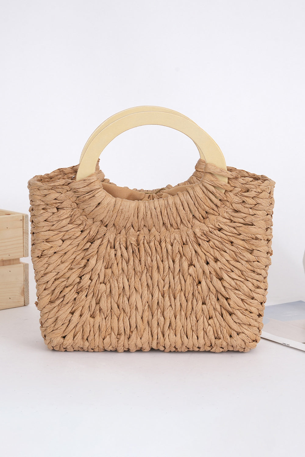 Bolsa de praia estilo vintage da Shewin em palha natural com alça redonda em madeira clara