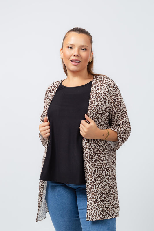 Mulher vestindo casaco estampado leopardo plus size da marca TCO, com blusa preta e jeans