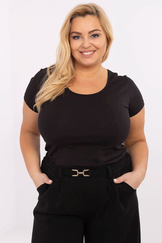 Mulher sorridente usando t-shirt preta plus size com calça preta e cinto elegante